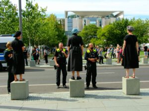 Die 3 Kassandras auf Piedestal vor Polizei